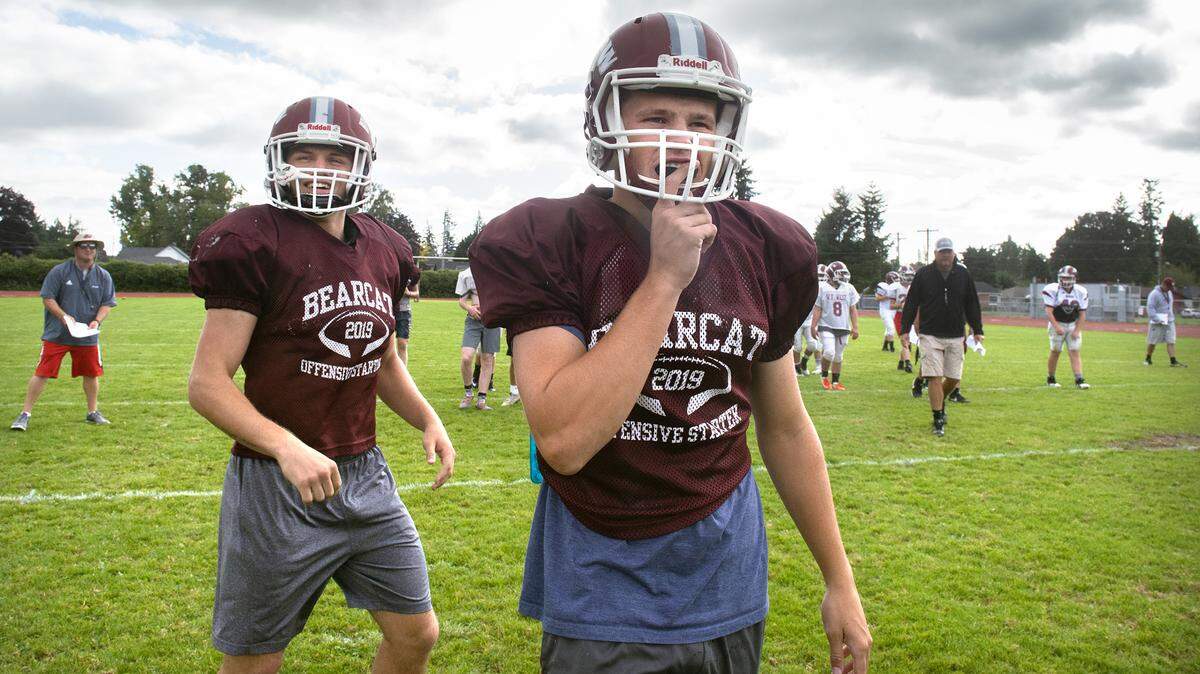 Chehalis head coach Dan Hill (far left) watches as unning back Jayden Camoza (left) and quarterback Josiah Johnson run through plays during football practice at W.F. West High School in Chehalis on Thursday, Sept. 26, 2019.