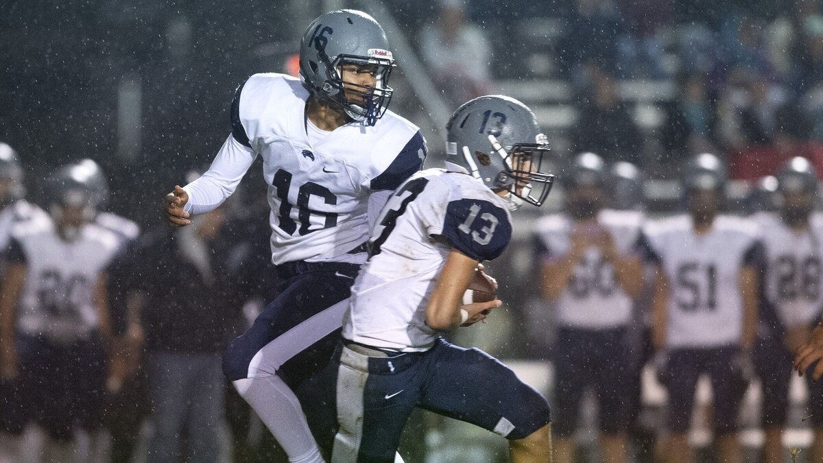 River Ridge quarterback Jevon Brown (16) hands off to running back Kieran Hunkin during Friday night’s football game at Eatonville High School on Oct. 5, 2018.