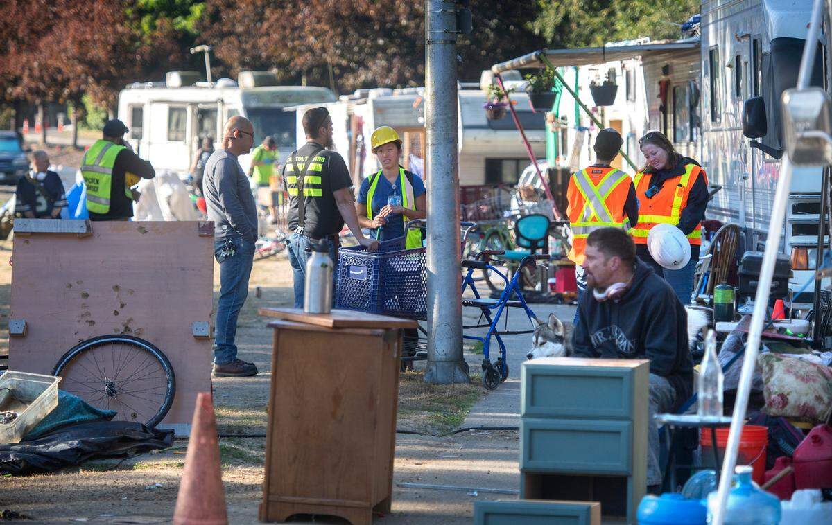 City work crews and crisis outreach workers gather to help with the clearing and relocation of residents living in their vehicles at the permitted RV parking area along Ensign Road in Olympia, Washington, on Wednesday, Sept. 21, 2022. The city plans to have the street completely cleared by mid-October.
