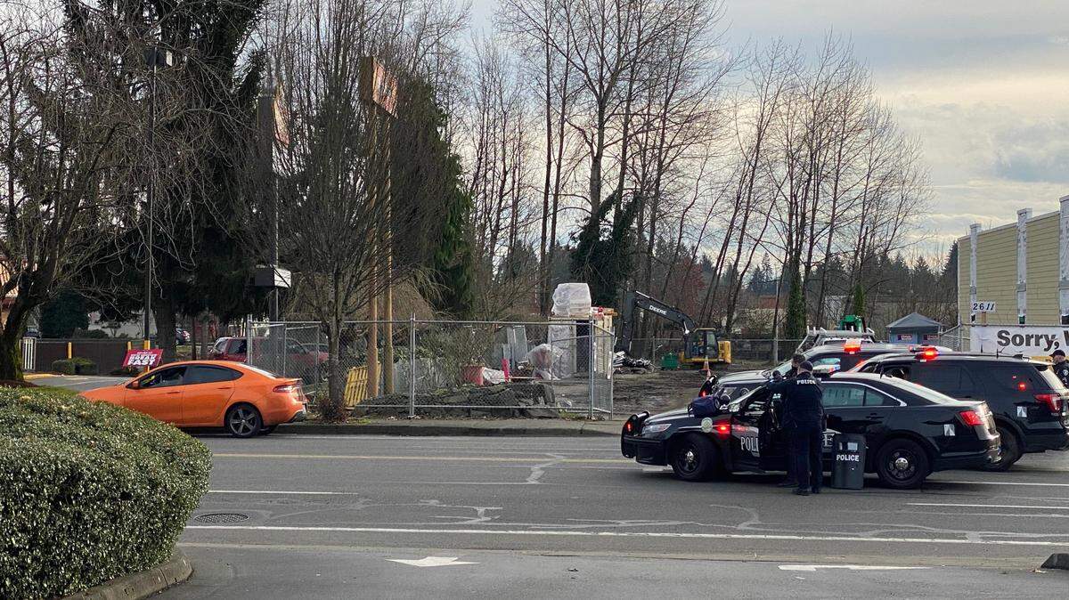 Olympia Police officers and a crisis response unit negotiate with a reportedly suicidal subject inside an orange car near 1st Security Bank on Harrison Avenue Northwest on Friday. Police shut down Harrison in both directions between Division Street and Kenyon Street and encouraged the public to avoid the area.