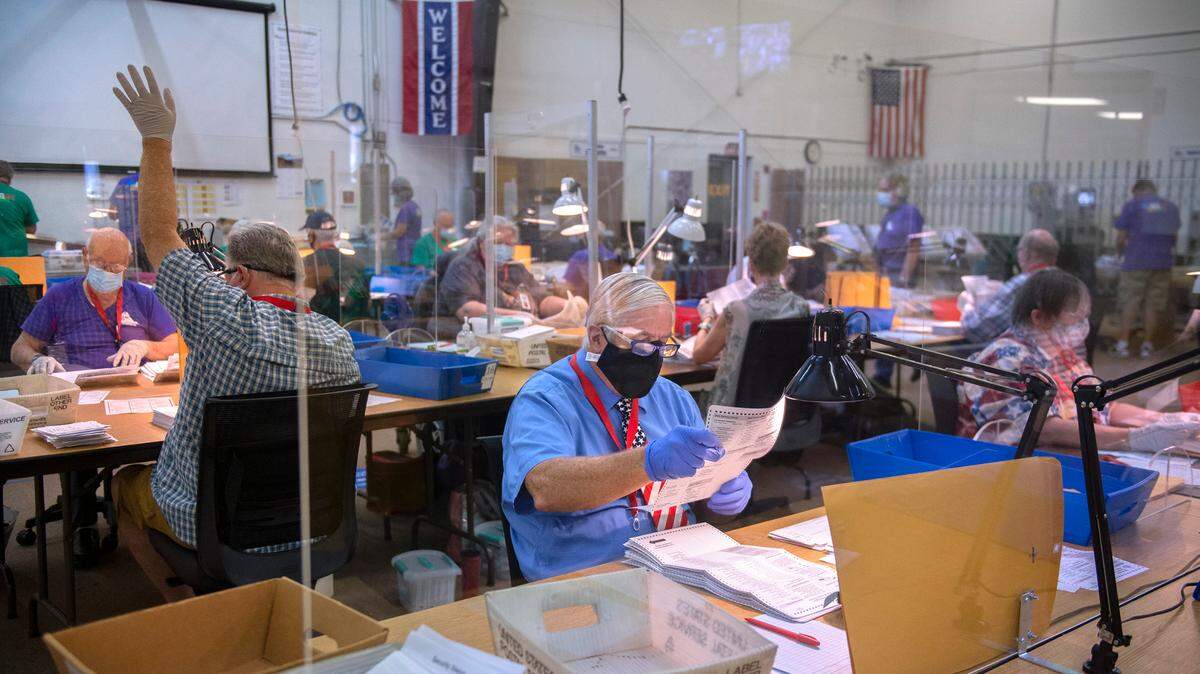 Workers count 2020 primary ballots at the Thurston County Elections Center in Tumwater.