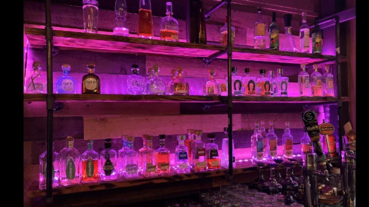 A photo of the El Sitio bar which shows missing bottles of alcohol.