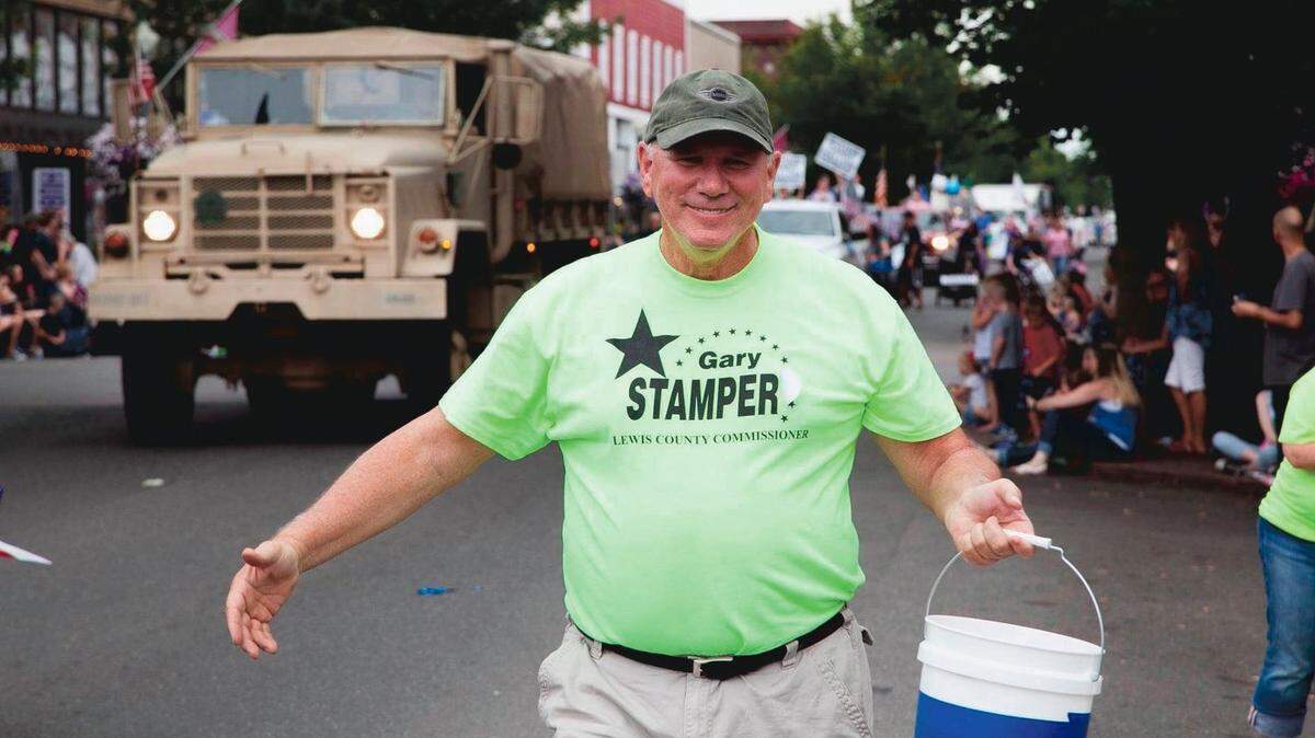 Lewis County Commissioner Gary Stamper smiles while walking in a parade in Centralia.