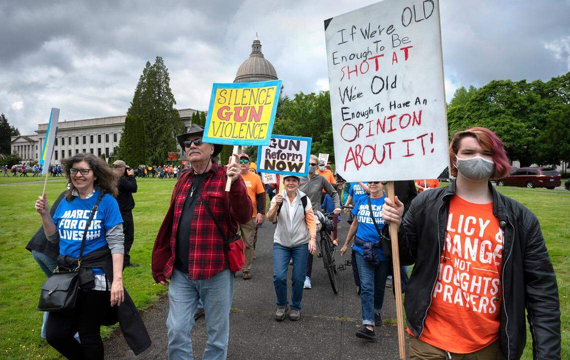 Jill Schmieder (from left), Chris Svehaug, Ruthi Winter, Patty Ahonen, all of Seattle, and Kaelan Tackett of Spanaway march with about hundreds of other gun-control advocates during the March For Our Lives at the state Capitol in Olympia on Saturday.