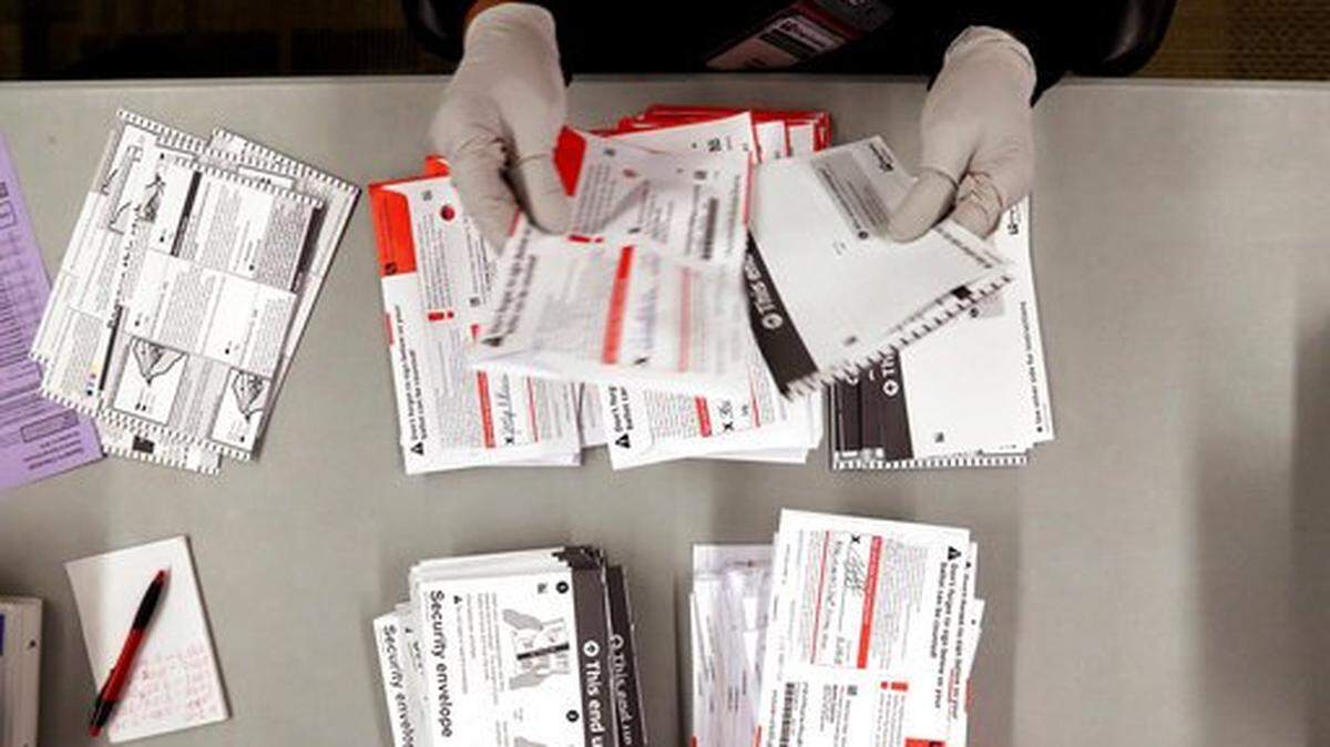 An election worker separates ballots from security envelopes at the King County Elections office in 2018.