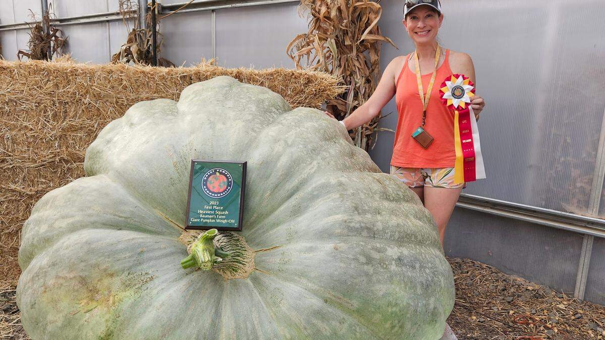 Cindy Tobeck poses with her 1,884-pound squash Oct. 10 at the Bauman’s Farm weigh-off in Gervais, Oregon. It may be the largest squash in the world. 