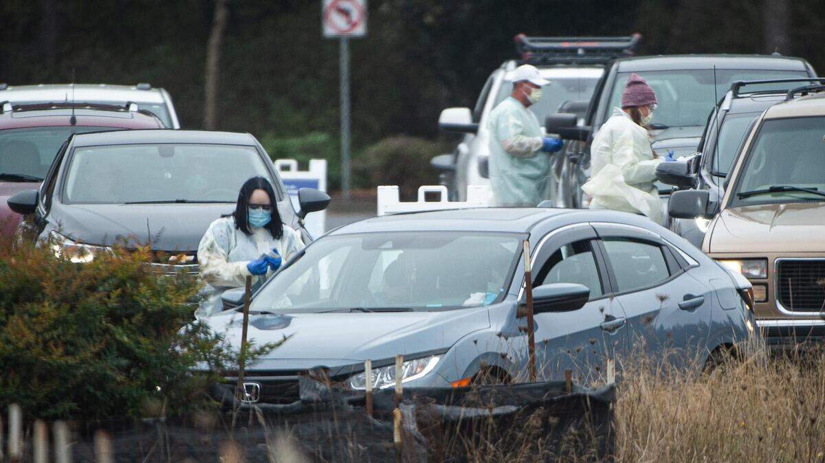 Cars line up as people wait for a drive-thru COVID-19 test at Providence Hawks Prairie Family Medicine in Lacey, Wash., on Friday, Oct. 16, 2020.