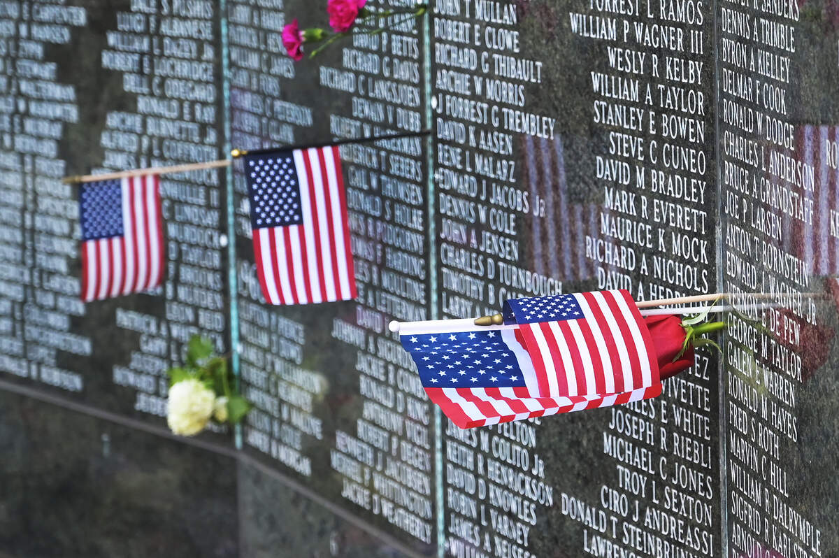 American flags placed with names on the Washington State Vietnam Veterans Memorial flutter with the breeze on the Capitol Campus Monday, May 30, 2022, in remembrance of Memorial Day.