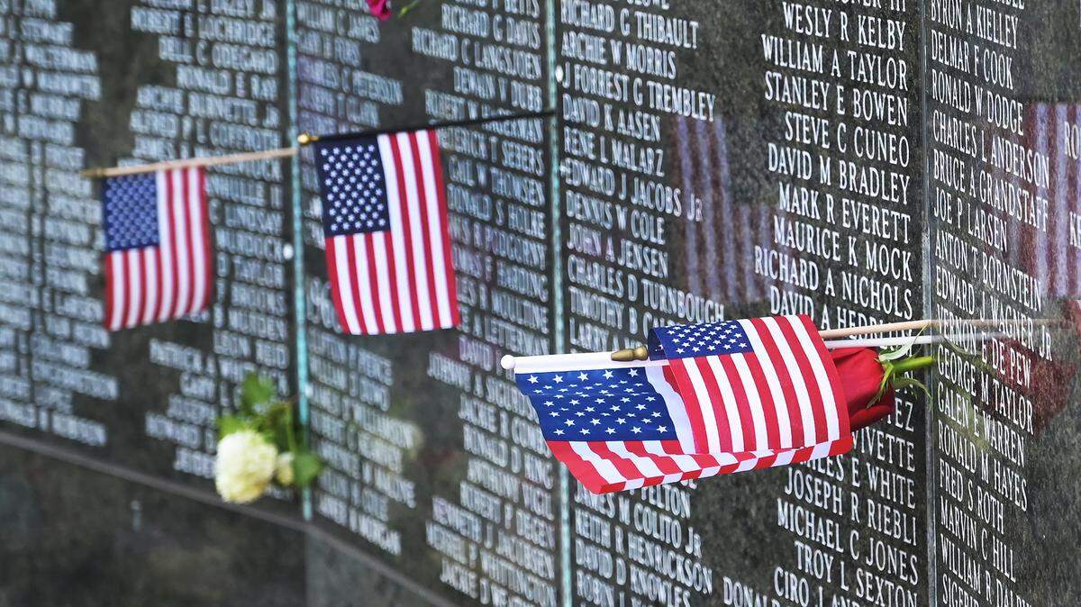 American flags placed with names on the Washington State Vietnam Veterans Memorial flutter with the breeze on the Capitol Campus Monday, May 30, 2022, in remembrance of Memorial Day.
