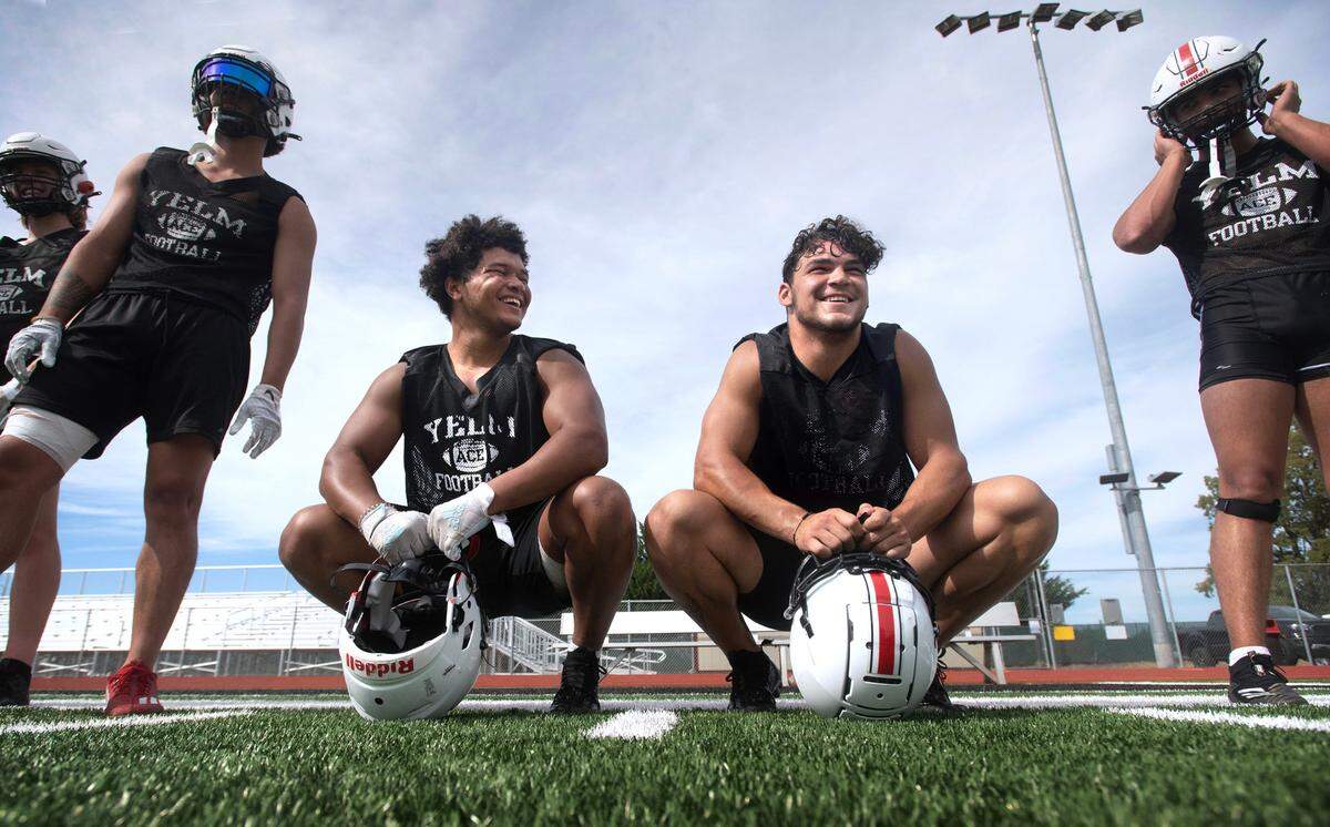 Yelm’s Isaiah Patterson (left) and Brayden Platt take a break between drills during the Tornados’ preseason football practice at Yelm High School in Yelm, Washington, on Thursday, Aug. 17, 2023.