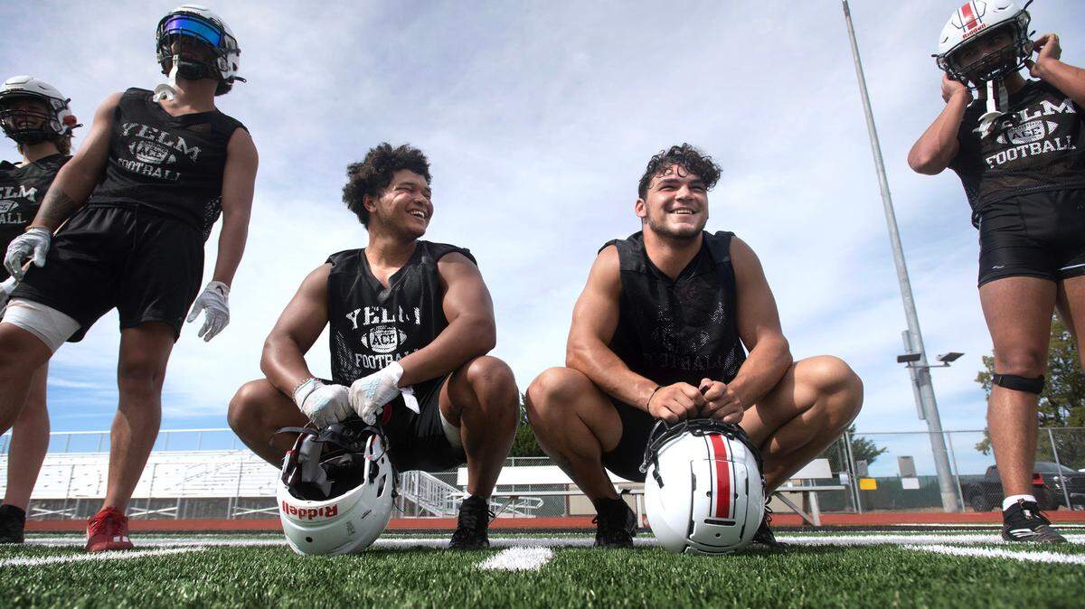 Yelm’s Isaiah Patterson (left) and Brayden Platt take a break between drills during the Tornados’ preseason football practice at Yelm High School in Yelm, Washington, on Thursday, Aug. 17, 2023.