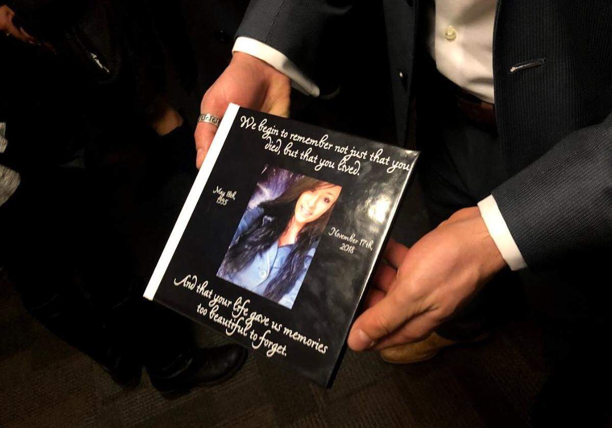Summer Scheibel’s brother holds a photo book the family presented to Thurston County Superior Court Judge Erik Price at the sentencing of Logan Ochoa, who admitted to killing Scheibel in 2018.