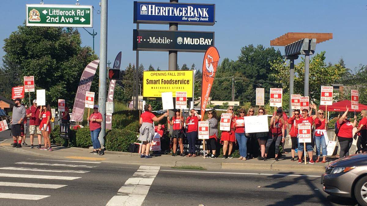 Tumwater teachers wave signs at Littlerock Road and Trosper Road on Thursday morning. Teachers have been on strike since Saturday, and now the Tumwater School District has filed an injunction to get them back to work.