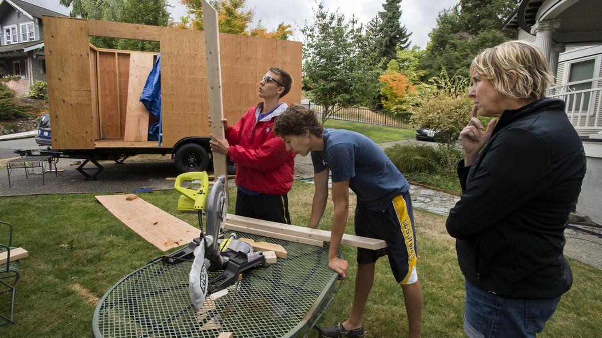 
Determining the proper length of rafter beams briefly stalls the team of Christina Seeburger, right, and her sons Chris Szigeti, 19, left, and Nick Szigeti, 17. The family project to build a tiny trailer house has presented a number of obstacles, most notably matching the schedules of three busy people.
