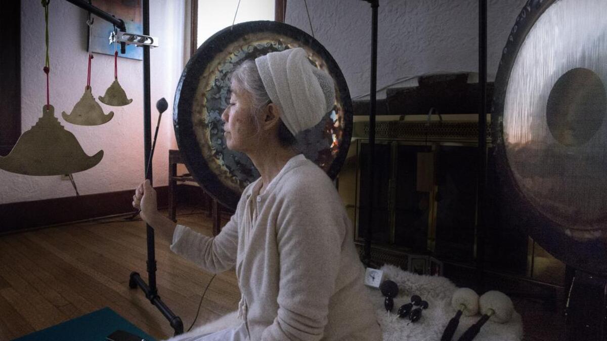 Yoga teacher Melissa Balch plays gongs in her Tacoma yoga class in March.