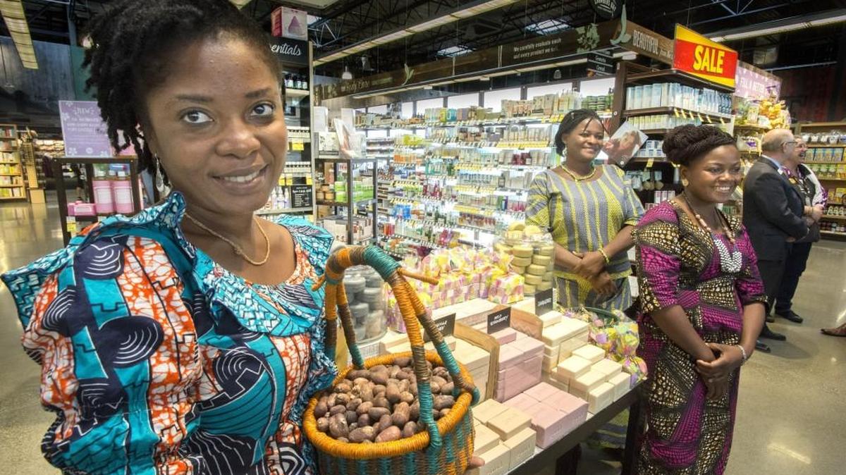 Mawulé Houmey holds a basket of shea nuts used in Alaffia products with fellow Togo countrywomen Ahoumondom Bamassi, center, and Abidé Awesso at a display at Whole Foods Market Chambers Bay in University Place on Tuesday.