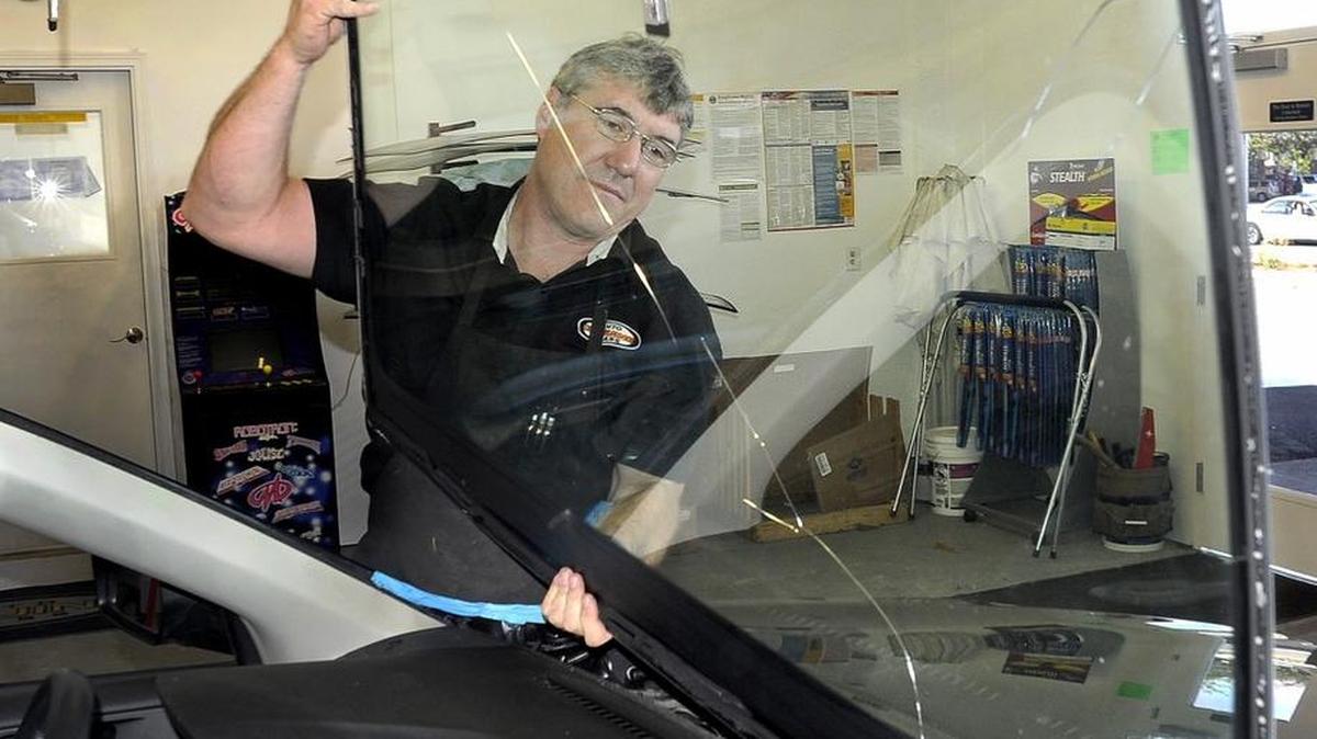 
Genuine Auto Glass owner John Pazar removes a cracked windshield from a late-model Subaru for replacement last week in his Lacey shop.

