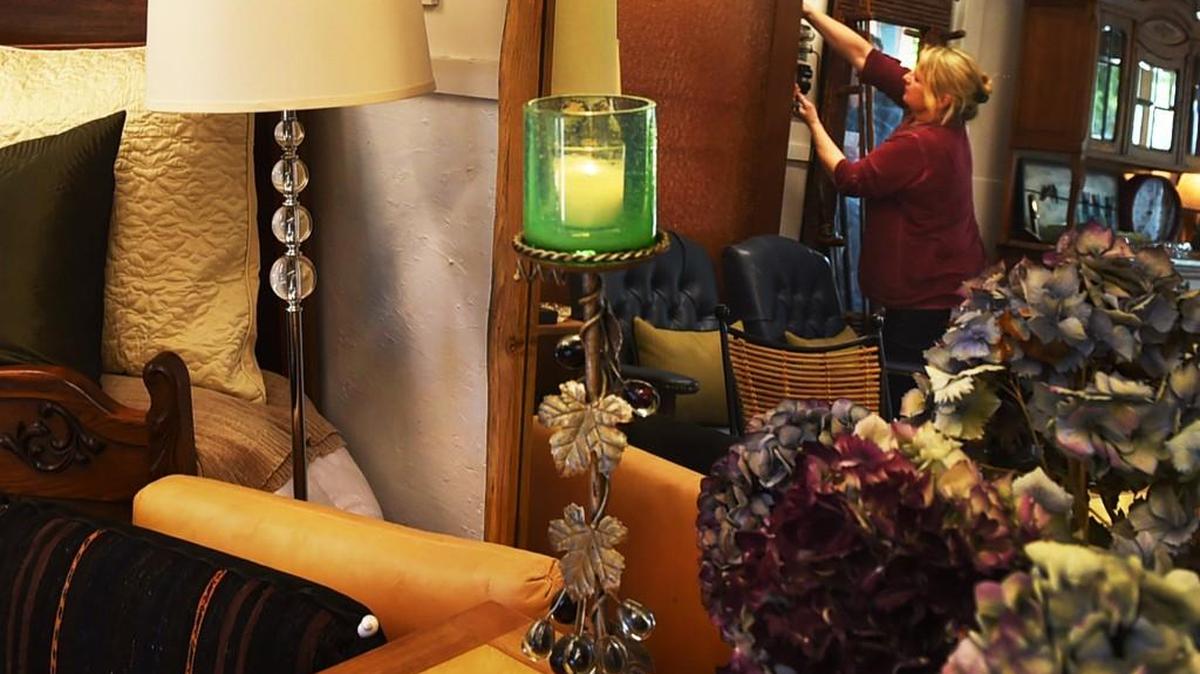 With the Mud Bay tidal flats as a backdrop to go with the rustic cabin setting, Bay Mercantile owner Kariann Pettibone is reflected in one of her own custom mirrors. photo taken April 25.