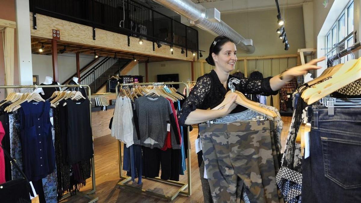 
Stocking inventory on the racks at her west Olympia store Sept. 21, Industrie Clothiers’ owner Amy Peters has years of experience as a corporate buyer from Nordstrom to draw from to use in her own business.
