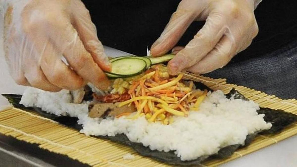 MiSo Asian Bistro co-owner Ryan Rommann prepares a chicken roll at his new Lacey restaurant.