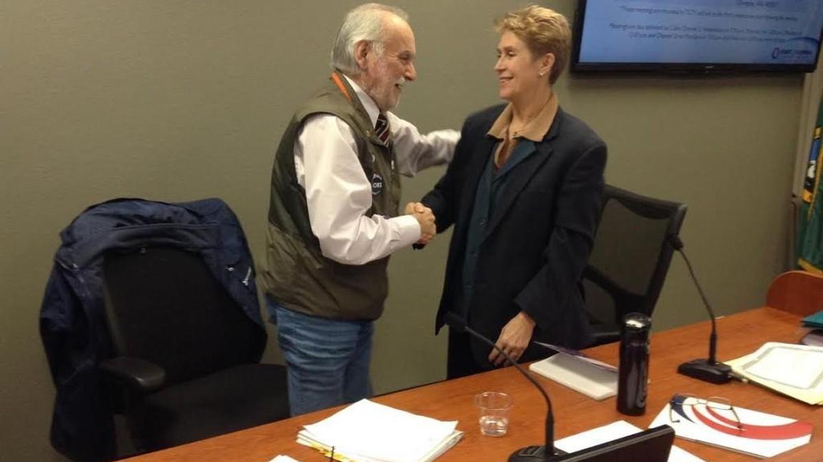 Incoming Commissioner E.J. Zita (right) and outgoing Commissioner George Barner embrace at the end of Monday’s Port of Olympia commission meeting. Barner wrapped up eight years on the commission.
