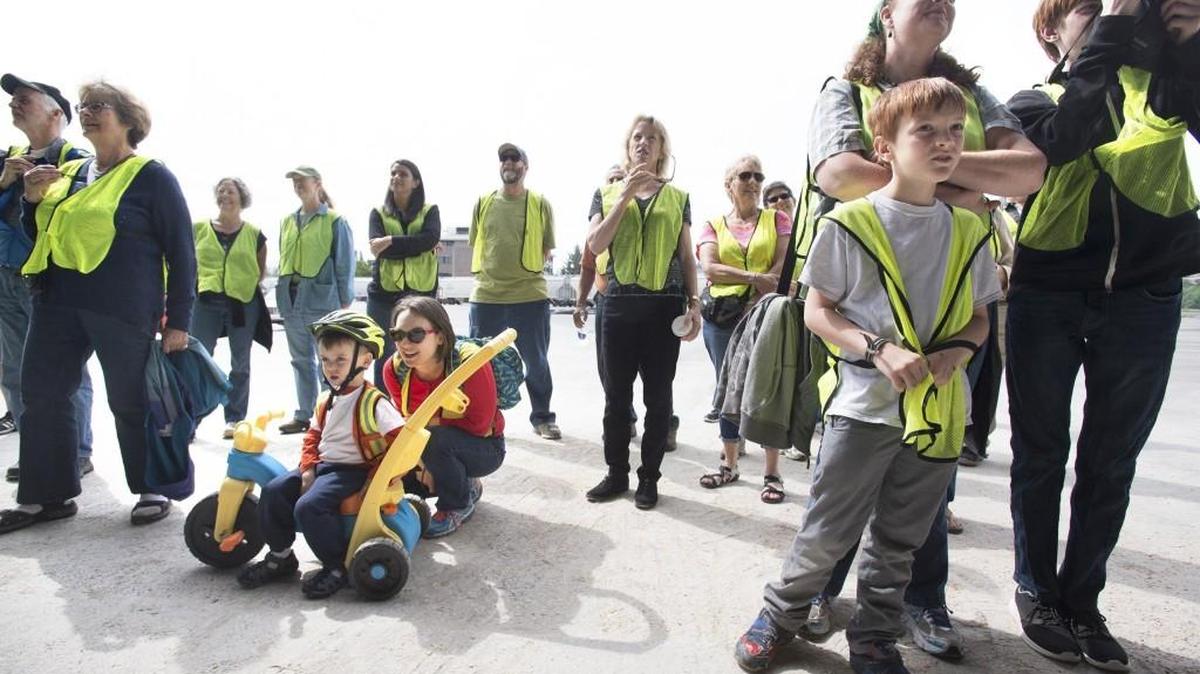 Members of the public don yellow vests as they watch longshoremen load a truck with organic feed corn from Turkey during a public tour of the Port of Olympia's "Working Waterfront" on Wednesday, May 18, 2016.