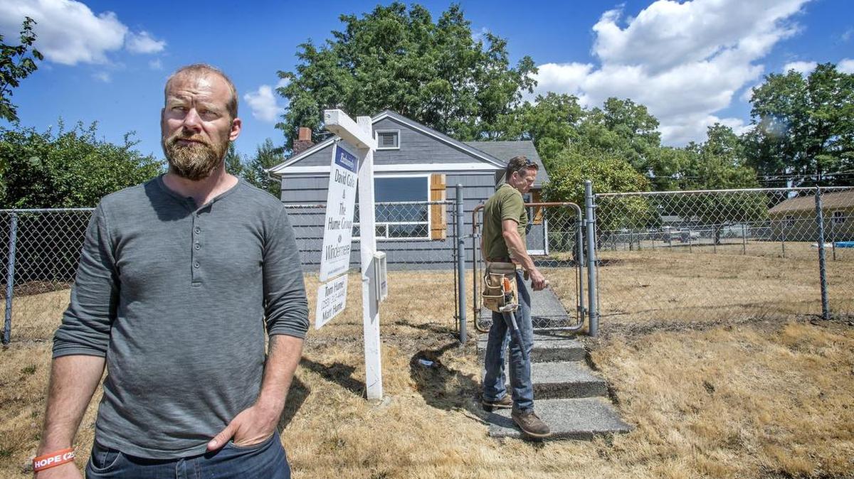 
David Gintz, a redeveloper who buys up bank-owned and uninhabitable properties and rehabs them for sale, has sold the house at 3301 S. Cushman three times, but thus far hasn't closed in 120 days due to underwriting issues. He and T-Town Builders partner James Staedler, center, check on the long-vacant house July 23. 
