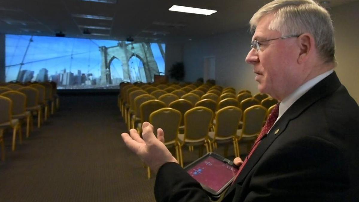Utilizing a tablet as its control center at Funeral Alternatives’ Tumwater location, co-owner Clair Ferris demonstrates the projected multi-sensory experience called ShareLife.