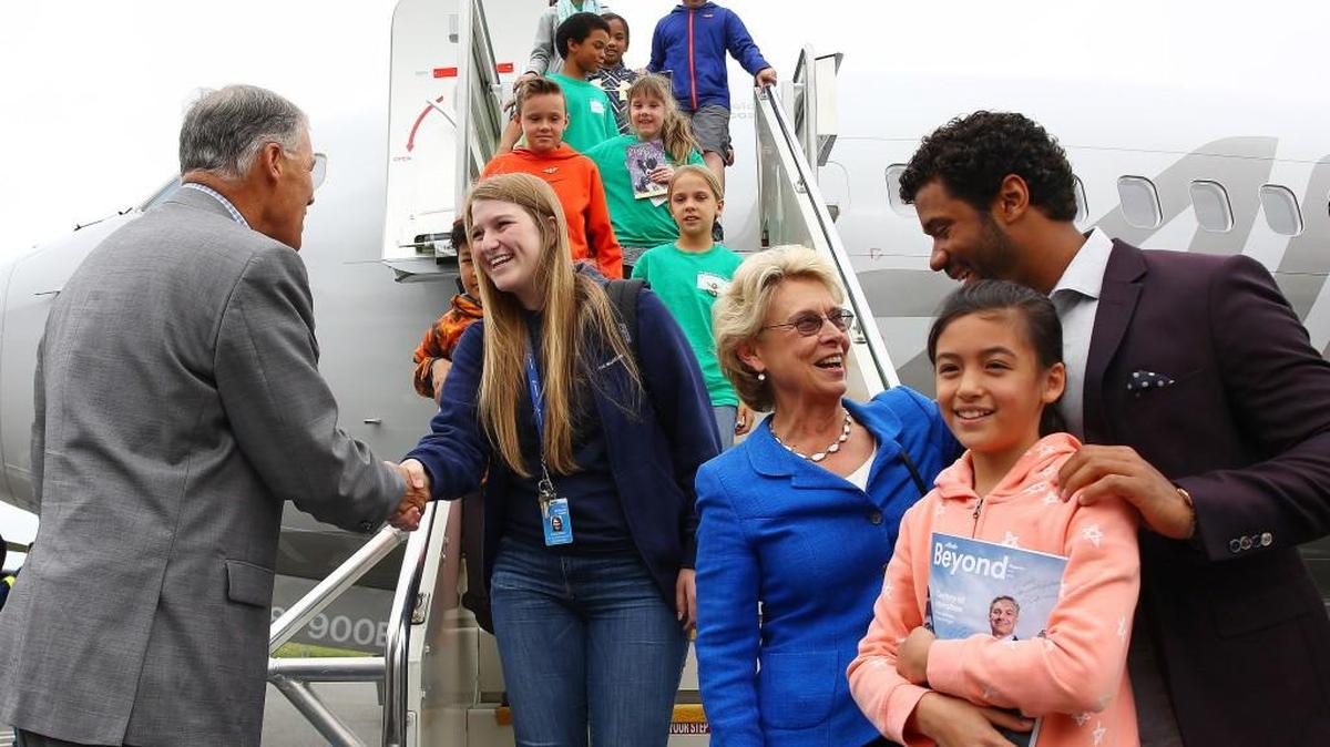 Gov. Jay Inslee, former Gov. Chris Gregoire and Russell Wilson greet Museum of Flight summer campers as they disembark a new Alaska Airlines 737 painted with a Boeing centennial theme during a kickoff celebration for Boeing's 100th anniversary month, Thursday at the Museum of Flight in Seattle.