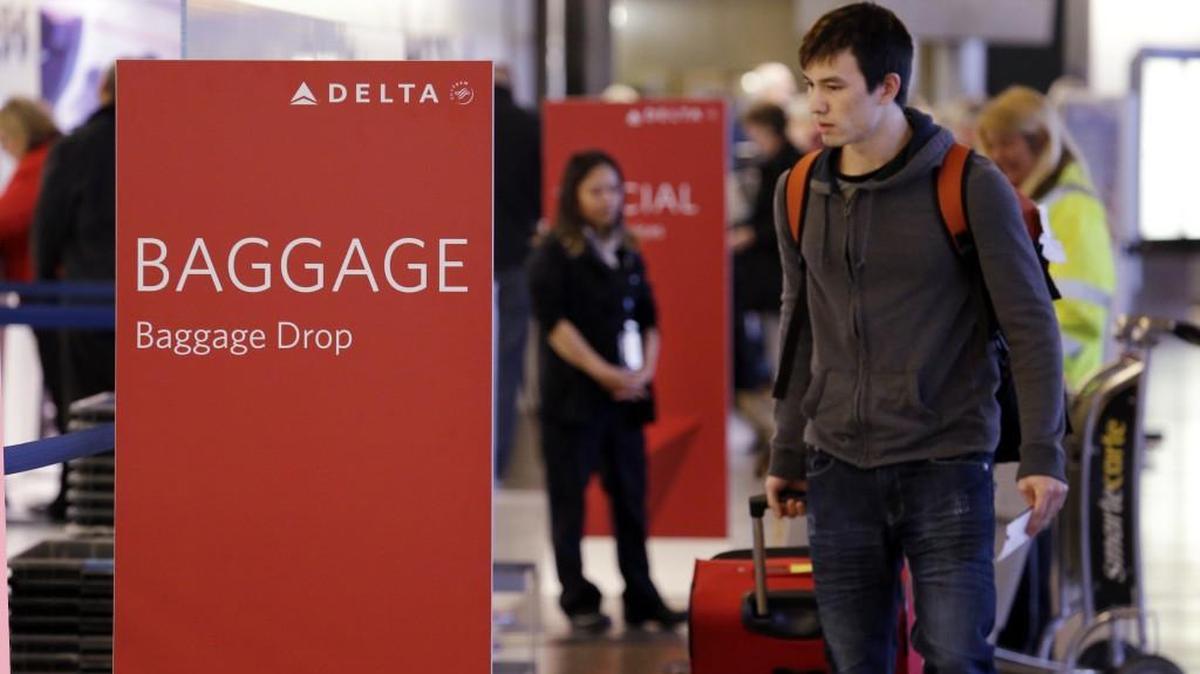 Travelers walk toward the baggage drop area for Delta Air Lines last year at Sea-Tac Airport. The Port of Seattle, which manages the airport, announced Thursday that 90 private contractors have been hired to assist with line management. Meanwhile, Transportation Security Administration workers will continue to perform necessary security-related duties.