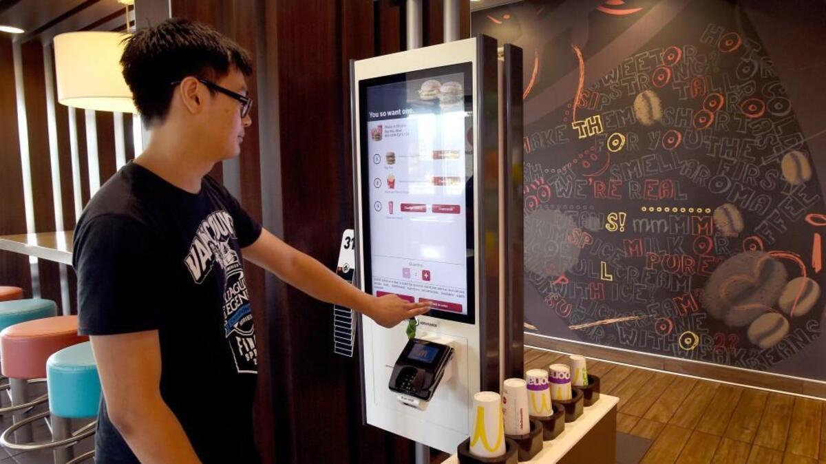 Familiar with their new kiosk ordering system from traveling regionally, David Phan places his order at the McDonald's restaurant on Black Lake Boulevard Aug. 30.