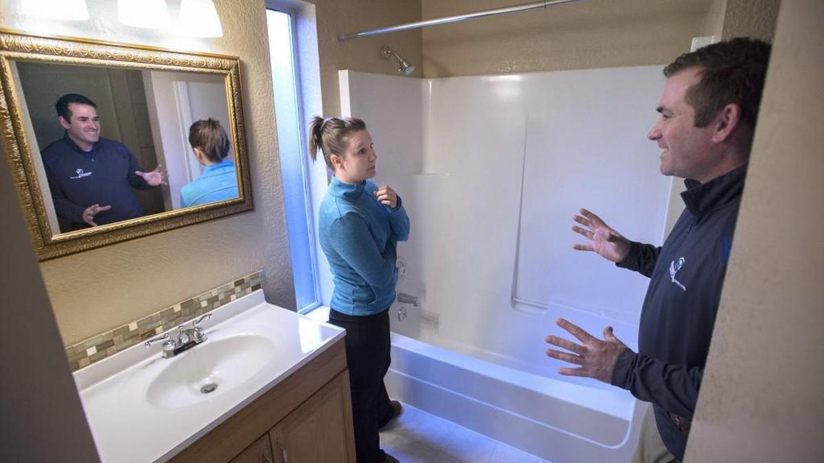 First-time home buyer Nicole Boatright, an assistant nutrition program director with the Clover Park School District, talks to home inspector Bill Ryan of Boggs Inspection Service during an inspection of a two-bedroom home in Tumwater that she is buying on Thursday, Jan. 21, 2016.