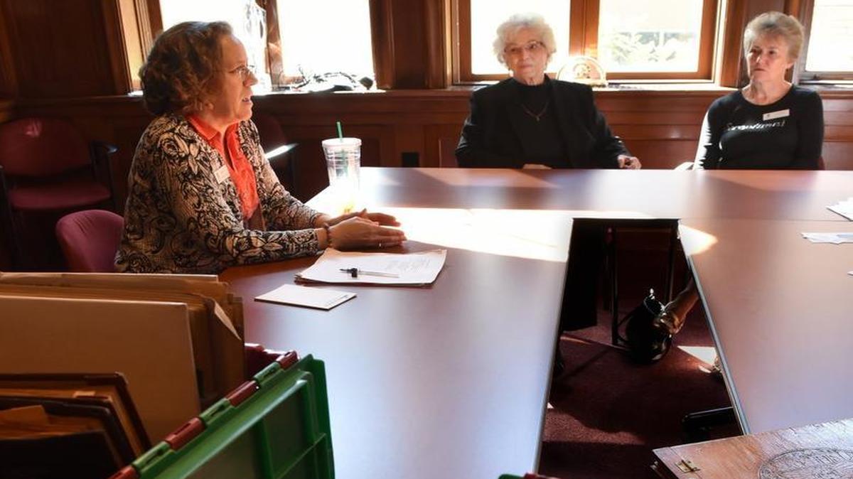 With several boxes full of scrapbooks filled with club-related photos and clippings collected over the decades, Olympia Soroptimist club members Karen Hall, Marti Ensign and Judy Miller (left-right) give an overview of the service organization's local history and mission Sept. 26 at the McCleary mansion.