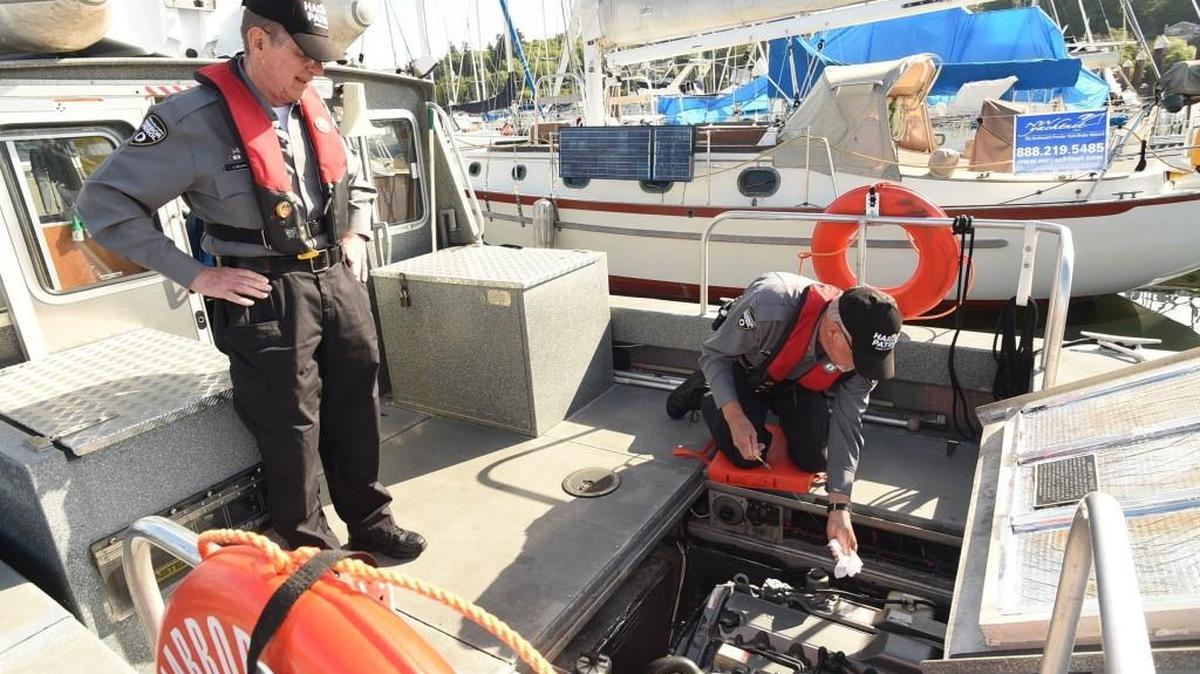 Port of Olympia Harbor Patrol Commanders Nick Kirchoff (right) and Jerry Gillming stop by the 28-foot patrol craft April 26 at its berth in the Swantown Marina.