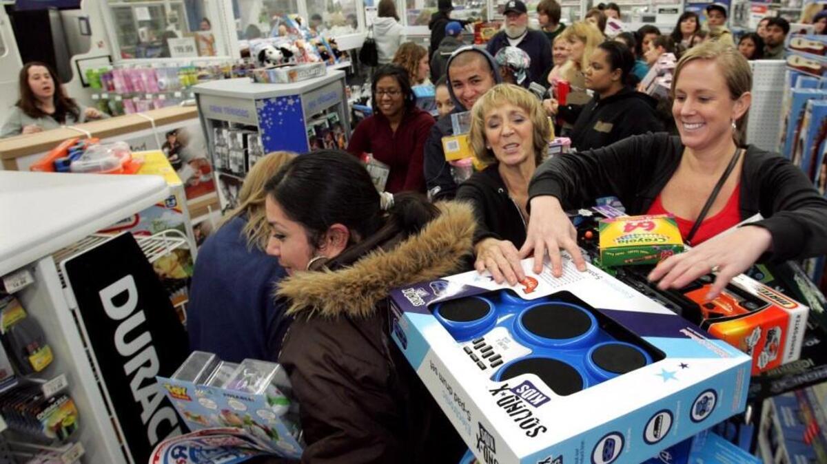 Jenifer Byquist (right) and her mom Debbie Morrison, center, act to keep toys from falling from their Toys R Us in Tacoma shopping cart at 12:45 a.m. the morning after Thanksgiving in 2009. The chain in the past has been open on Thanksgiving followed by an early opening on Black Friday.