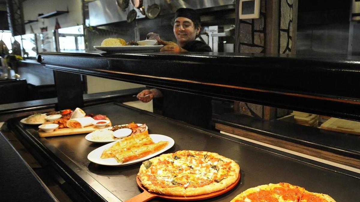 Lead line chef William Blake Tilley adds another dish to the server pick-up station. A variety of dining options are evident by the row of completed menu orders Sunday afternoon at the Mediterranean Breeze restaurant located off Harrison Avenue in west Olympia. photo taken Feb 28,2916