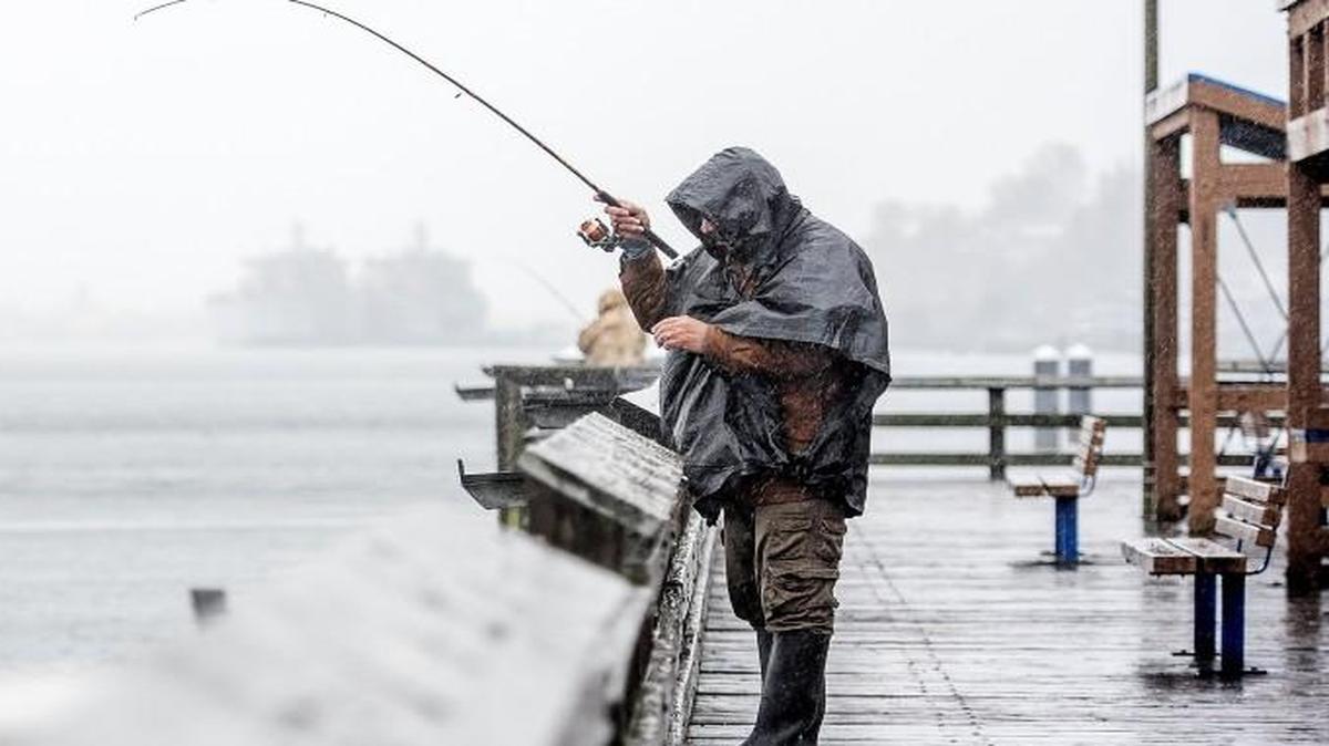 Staff file: Manuel Tafoya, of Lakewood, fishes on a fishing pier along Ruston Way in a rain and wind storm Tuesday Nov. 17, 2015. Tafoya caught a pail full of squid after a morning of fishing. Learn about Puget Sound squid fishing at an event on Thursday in Lacey.