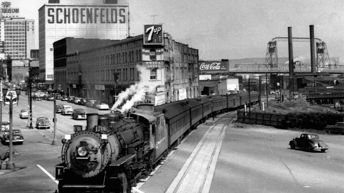 Tacoma railroad historian Jim Fredrickson took this photo of an Army troop train heading to Fort Lewis in 1951. The train crosses Pacific Avenue at Hood Street, with the Croft Hotel, also known as the Savoy Hotel, in the background. The site became home to the Tacoma Art Museum.