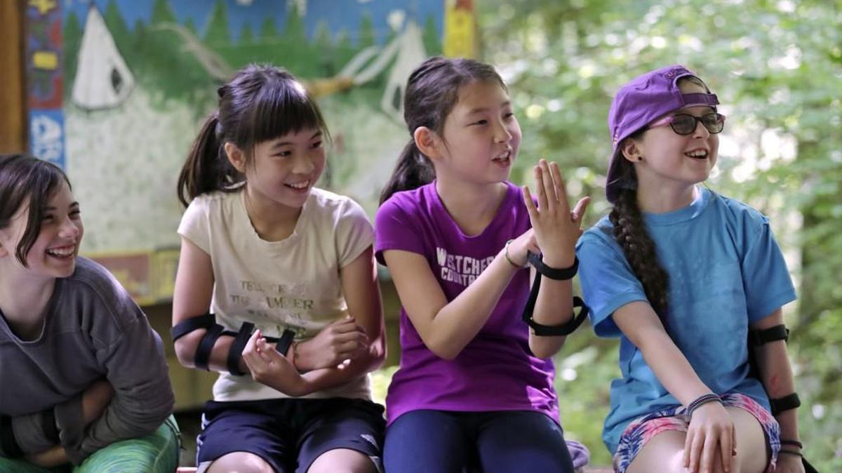 Girl Scouts Ket Davis, left, Em Kong, Lily Pogue and Rowan Rhoads laugh as they try to figure out a hand signal at a Girl Scout day camp in Carnation, Wash., on Tuesday, June 26, 2018. As American women seek a larger role in politics, fairer wages and an end to sexual harassment, the Girl Scouts see an opportune time to show some swagger in promoting their core mission: girl empowerment. (AP Photo/Elaine Thompson)