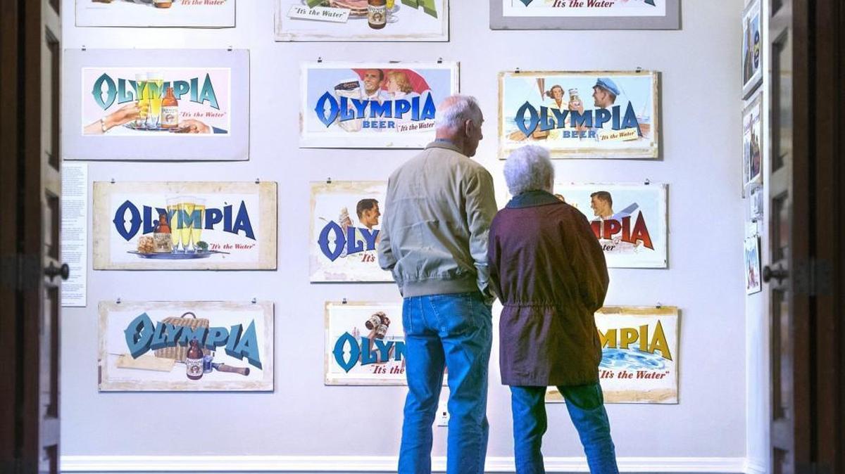 Retired Olympia Brewing Co. worker Joe Lohrengel his wife, Doris Lohrengel, take in the nostalgia during the opening of “It’s the Art” at the Schmidt House in Tumwater on Saturday.