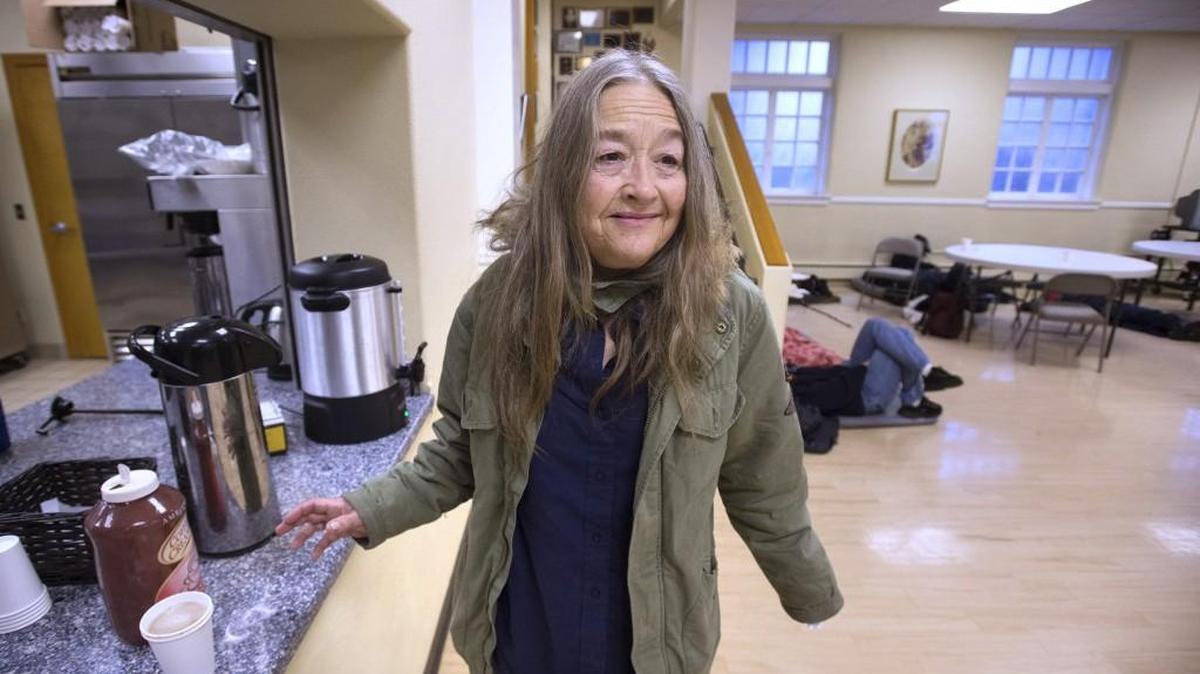 Kathleen Gallaher smiles as she sees a friend arrive at the Interfaith Works Winter Warming Center at Temple Beth Hatfiloh, one of three downtown Olympia faith communities that are hosting the daily daytime operations.