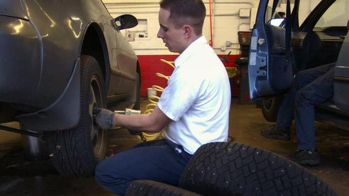 Beau Miller changes out a set of studded tires at the downtown Olympia Les Schwab store in 2005.