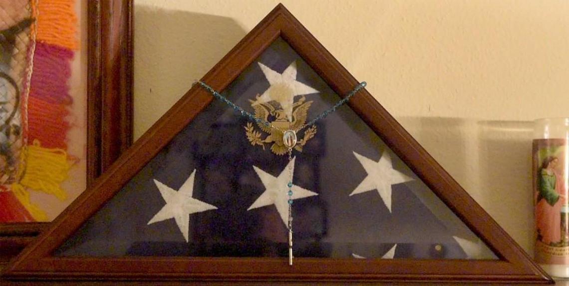 The flag that covered Michael Anthony Rude’s casket is prominently displayed in his parents’ home.