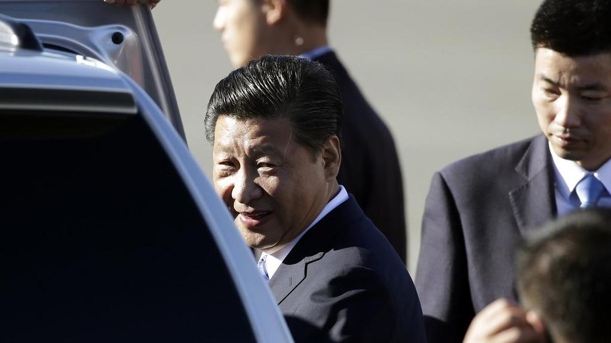 
Chinese President Xi Jinping is surrounded by a security detail as he gets into a car after arriving Tuesday at Boeing Field in Everett. 
