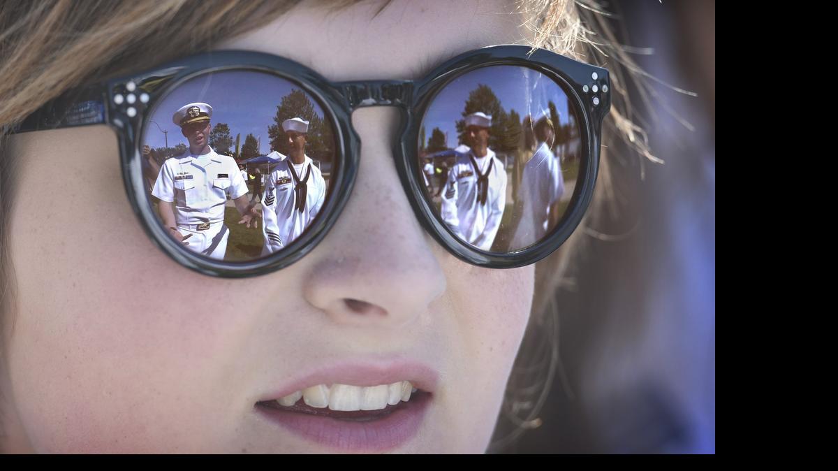 
Crew members from the USS Olympia nuclear powered submarine Lieutenant Junior Grade Zachary Copes (left) and Machinist's Mate First Class Kyle Hulett are reflected in the sunglasses of Capital Lakefair princess Madeline Poultridge as she met the sailors at Heritage Park in Olympia on Friday


