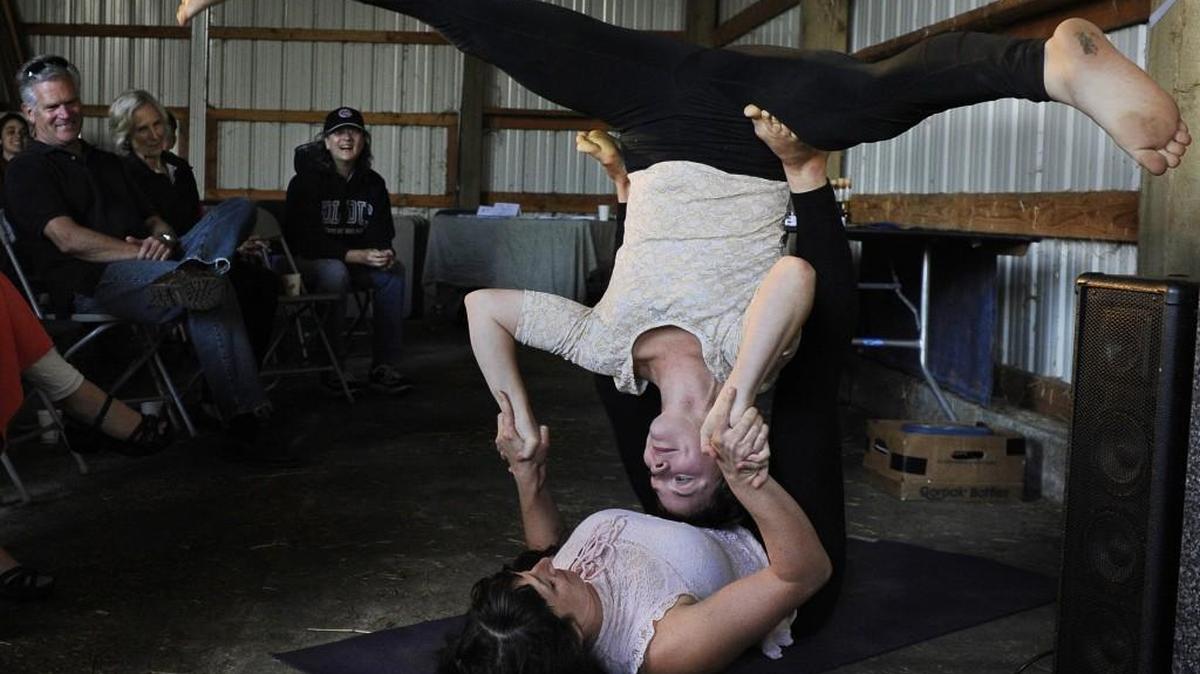 
Assisted by yoga partner Abigail Upshur, Acrojules' owner Julianne Panagacos demonstrates Acroyoga at the Enterprise for Equity Micro-Business Showcase event Sept. 20 at the Scatter Creek Farm and Conservancy in Rochester, the site for the organization's new incubator farm. One of the class’ graduates, Panagacos' business blends asana yoga poses and weight sharing movements in a partnered yoga setting.
