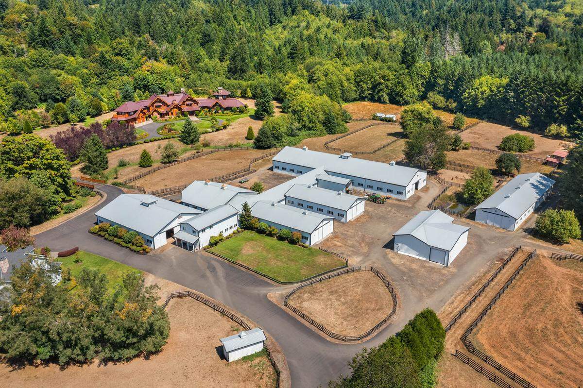 The equestrian estate includes nine barns with 70 horse stalls, indoor riding arenas and fenced pastures, a caretaker home, staff apartments and more.