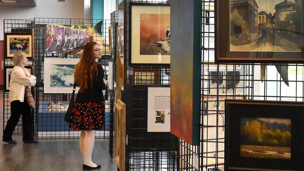 Noon visitors check the varied entrants in the Olympia Art League’s second juried art show in The Olympia Center during the 2018 Spring Arts Walk.