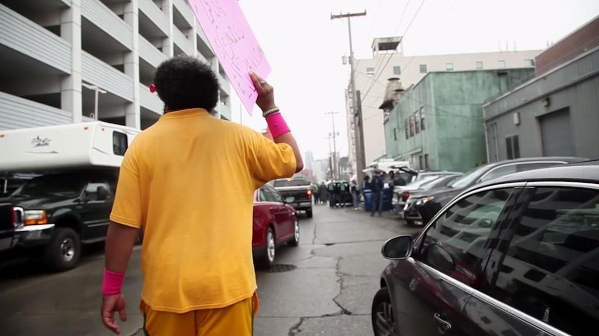 In a still from the documentary "Superfan" Kris Brannon carries a sign promoting the return of an NBA team to Puget Sound. The film about the Sonics Guy was made by Leigh Burmesch.