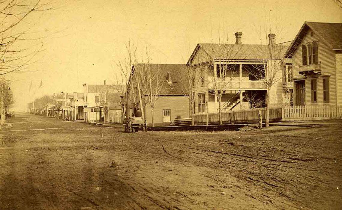 In the 1870s, the commercial center of Olympia was still north of Fourth Avenue. In this 1876 photo, we are looking north down Main Street (Capitol Way) from around Sixth Avenue (now Legion Way). Residences are in the foreground, with shops, restaurants and hotels in the distance. Image selected and captioned by Deborah Ross on behalf of the Olympia Historical Society and Bigelow House Museum, https://olympiahistory.org.